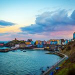 multicolored buildings near cove under cloudy sky